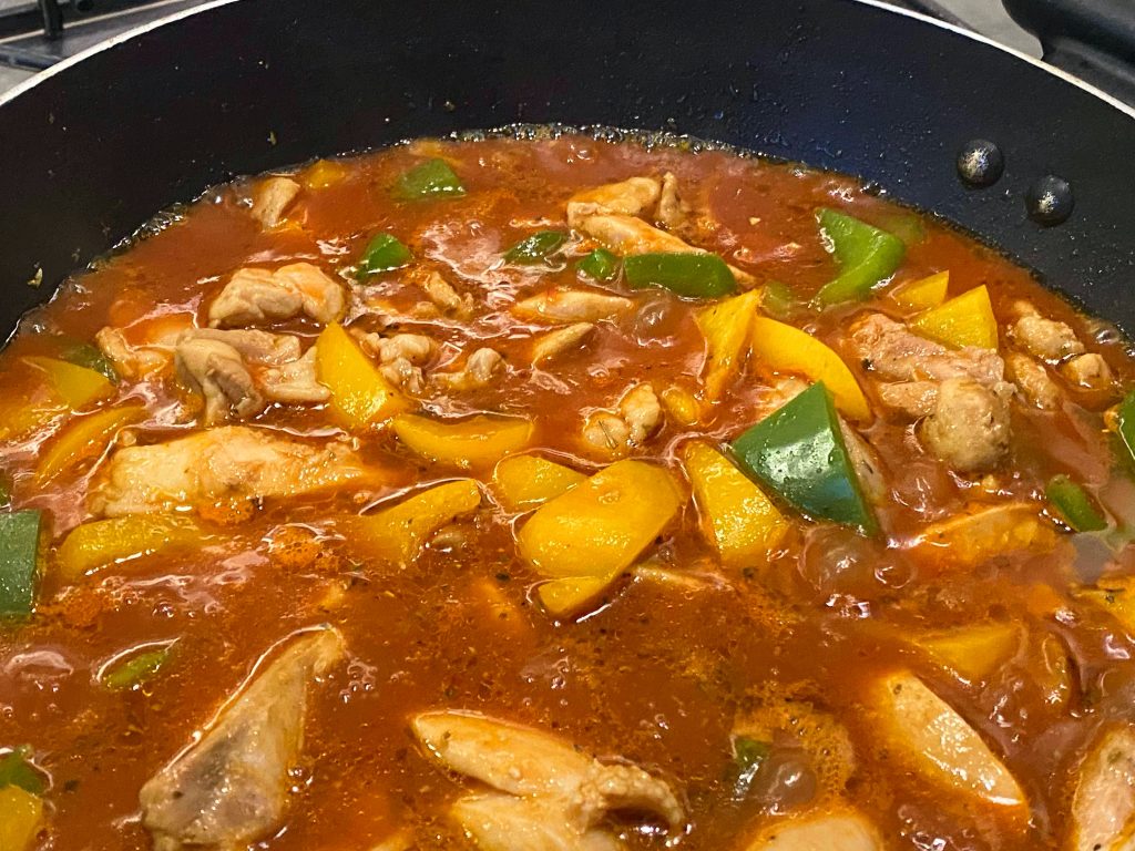 Chicken and peppers cooking in Cola sauce